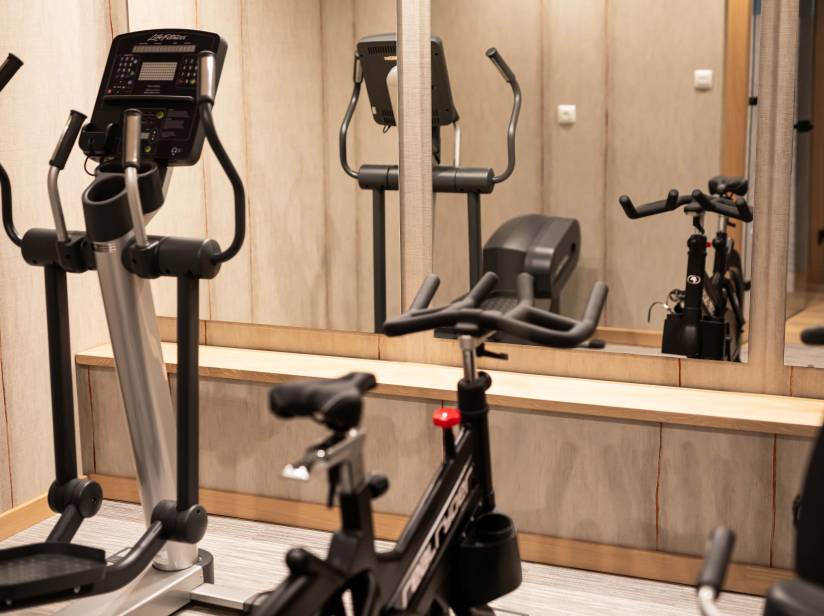 Sala z rowerkami treningowymi oraz orbitrekiem do ćwiczeń w hotelu Piast Opole.